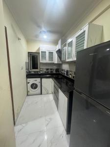 eine große Küche mit weißen Schränken und Geräten in der Unterkunft Rosebank service Apartment in Arpora