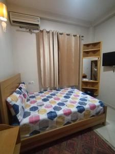 ein Schlafzimmer mit einem Bett mit einer bunten Bettdecke in der Unterkunft Maison d'hôte Najah 1 in Khenifra