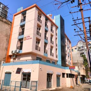 an apartment building on a street corner at Hotel Madhav Shankar in Rajkot
