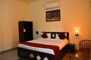 una camera con un letto con una coperta rossa e bianca di Ranthambore Village Serai a Khilchīpur Altre 13 foto