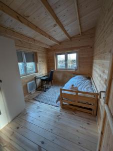 Schlafzimmer einer Blockhütte mit einem Bett und einem Schreibtisch in der Unterkunft Chalet lohr in Lohr