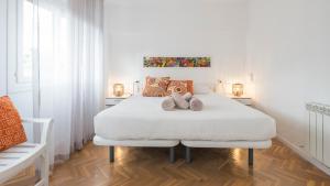 una camera bianca con un letto con due peluche sopra di Casa Paseo del Tajo Parking Incluido - Living Toledo a Toledo