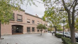 un edificio in mattoni con macchine parcheggiate di fronte di Casa Paseo del Tajo Parking Incluido - Living Toledo a Toledo