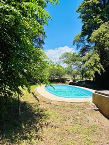 a swimming pool in a yard with trees at Casa Q a 5km del centro de Villa Carlos Paz in Villa Santa Cruz del Lago