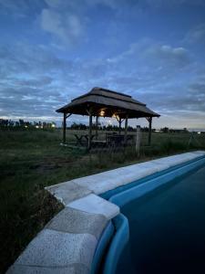 een prieel met een tafel en een zwembad bij Epona in Marcos Paz