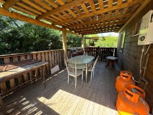een houten terras met een tafel en stoelen erop bij Cabañas Granja Paraíso in Molina