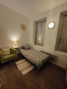 een slaapkamer met een bed, een stoel en een raam bij AB Studio in Roubaix +1 foto