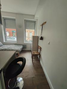 een kamer met 2 bedden, een bureau en een stoel bij AB Studio in Roubaix