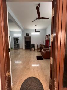 a living room with a ceiling fan and a couch at MUBSS Homestay in Tiruchirappalli
