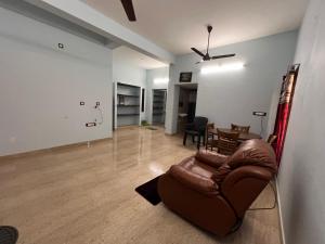 a living room with a couch and a table at MUBSS Homestay in Tiruchirappalli