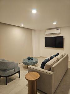 a living room with a couch and a flat screen tv at Beautiful Ocean View Apt Salinas Malecon Pier in Salinas