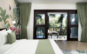 een slaapkamer met een bed en een balkon bij The Forest in Siem Reap
