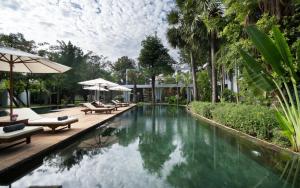 een zwembad op een resort met stoelen en parasols bij The Forest in Siem Reap