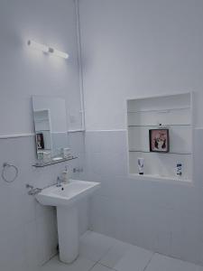a white bathroom with a sink and a bath tub at The Deane Residence Family Room in Colombo