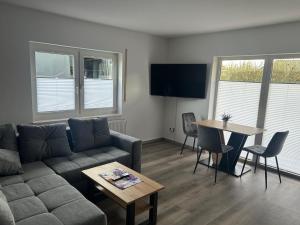 een woonkamer met een bank en een tafel bij Ferienwohnungen zur Elsa in Waldeck