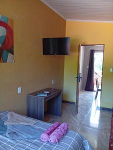 ein Schlafzimmer mit einem Bett und einem Fernseher an der Wand in der Unterkunft Cozy house in Matariz Beach in Angra dos Reis + 8 Fotos