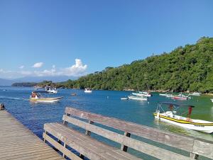a group of boats on the water near a dock at Cozy house in Matariz Beach in Angra dos Reis