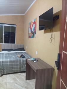 ein Schlafzimmer mit Bett und Flachbildfernseher in der Unterkunft Cozy house in Matariz Beach in Angra dos Reis