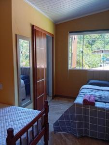 ein Schlafzimmer mit zwei Betten und einem Fenster in der Unterkunft Cozy house in Matariz Beach in Angra dos Reis