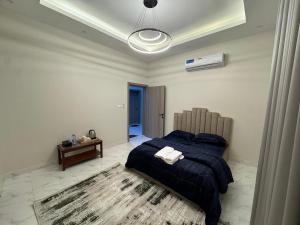a bedroom with a bed with a blue blanket and a rug at Faj Residence home stay in Ajman 