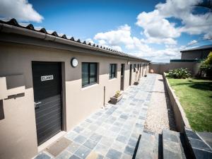 ein Gebäude mit Garage und Gehweg in der Unterkunft Umbono Private Game Lodge in Alexandria