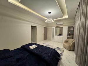 a bedroom with a bed and a chair in it at Faj Residence home stay in Ajman  +8 photos