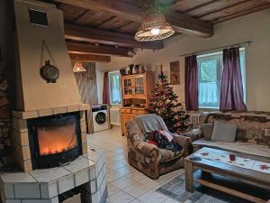 een woonkamer met een open haard en een kerstboom bij Chata Kubko in Bobrovník