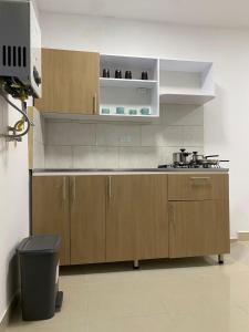 a kitchen with wooden cabinets and a stove at Apartahotel Provenza in Medellín