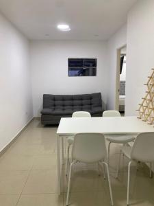 a room with a table and chairs and a couch at Apartahotel Provenza in Medellín