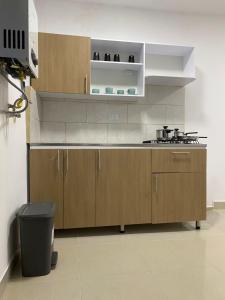 a kitchen with wooden cabinets and a trash can at Apartahotel Provenza in Medellín +33 photos