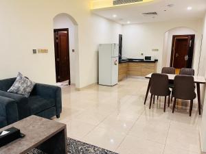 a living room with a couch and a table and a kitchen at Mabeet Al-Khobar in Al Khobar