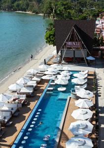 een strand met witte parasols en een zwembad bij Koh Chang Resort in Ko Chang