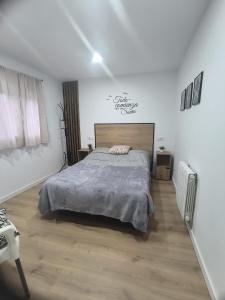 a bedroom with a bed in a white room at Los Cala-Vivienda tranquila en casa unifamiliar in Vigo