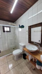 een badkamer met toilet en wastafel bij Pousada Uluwatu, Praia do Rosa in Praia do Rosa