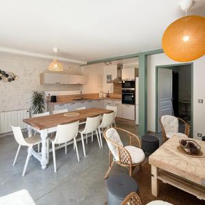 une cuisine et une salle à manger avec une table et des chaises dans l'établissement Les gîtes du pied mulet, à La-Gripperie-Saint-Symphorien