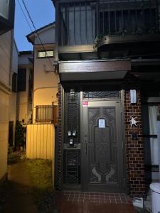 een toegang tot een gebouw met een zwarte deur bij 望月ハウス101 in Tokyo