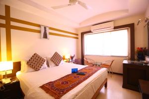 a bedroom with a bed and a large window at Capital O J Service Appartment in Chennai +24 photos