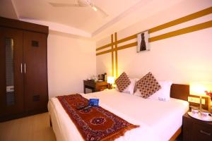 a bedroom with a bed with a cross on the wall at Capital O J Service Appartment in Chennai