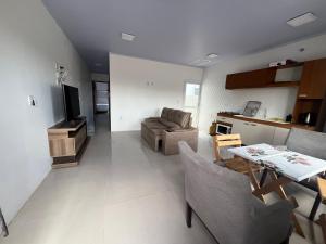 a living room with a couch and a table at Geminado Praia pérola in Passo De Torres