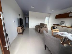 a living room with a couch and a table at Geminado Praia pérola in Passo De Torres