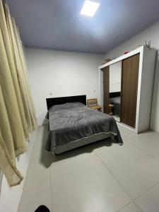 a bedroom with a bed and a mirror in it at Geminado Praia pérola in Passo De Torres