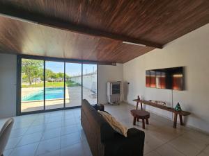 een woonkamer met een bank en uitzicht op een zwembad bij Chácara Urbana in Juazeiro