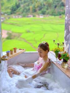 een klein meisje zit in een bad met bubbels bij เวนิสบ้านเวร in Ban Khun Nam Nan +170 foto's