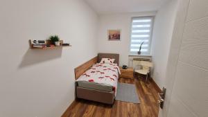 a small bedroom with a bed and a window at Sabina apartmani in Tuzla +1 photo