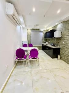 una sala da pranzo con sedie viola e tavolo di Iris life حياة ايريس a Gedda