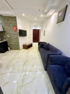 un soggiorno con 2 divani blu e una TV di Iris life حياة ايريس a Gedda