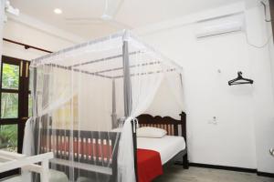 a bedroom with a bed with a canopy at Villa Arcadia in Tangalle