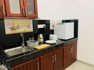 a kitchen counter with a sink and a microwave at Villa Arcadia in Tangalle