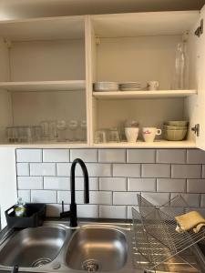 een keuken met een wastafel en een aanrecht met borden bij Maison f2 avec cour privative in Montceau-les-Mines +16 foto's