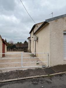 een hek voor een gebouw met een parkeerplaats bij Maison f2 avec cour privative in Montceau-les-Mines